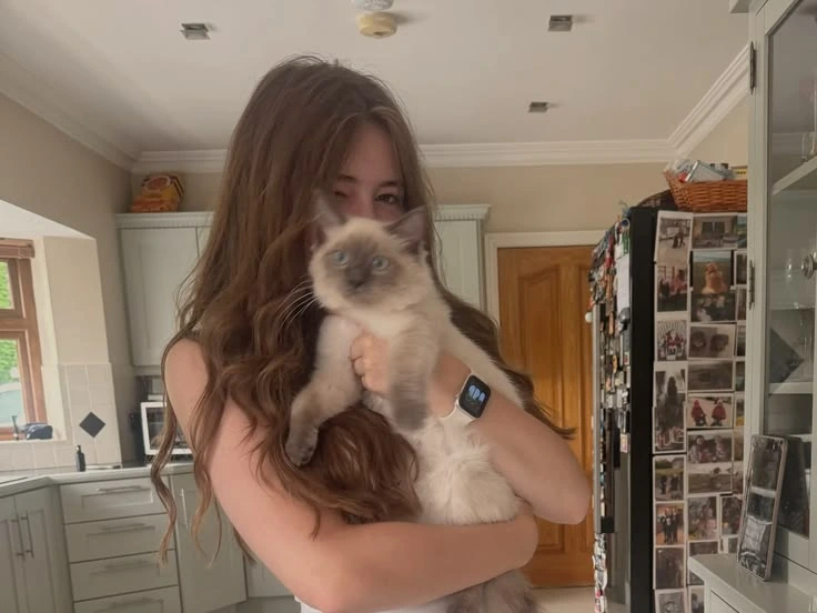 Woman holding a cat in a kitchen before background removal